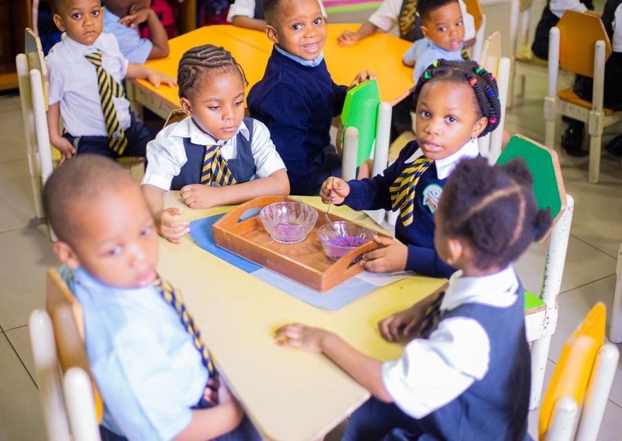 Nursery pupils working on a Montessori activity at a low table