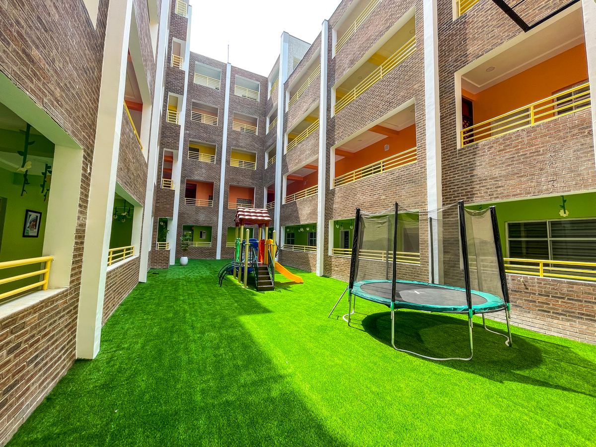 The courtyard play area with artificial turf and a trampoline