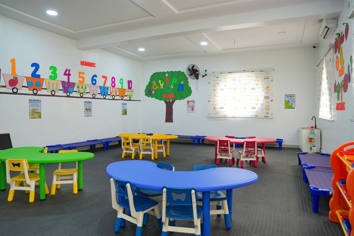 A bright nursery classroom with child-height tables and colourful chairs