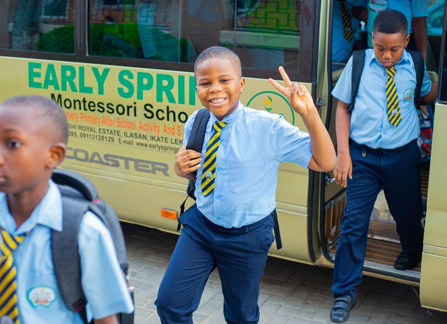 A smiling elementary pupil arriving at school on the Early Spring bus