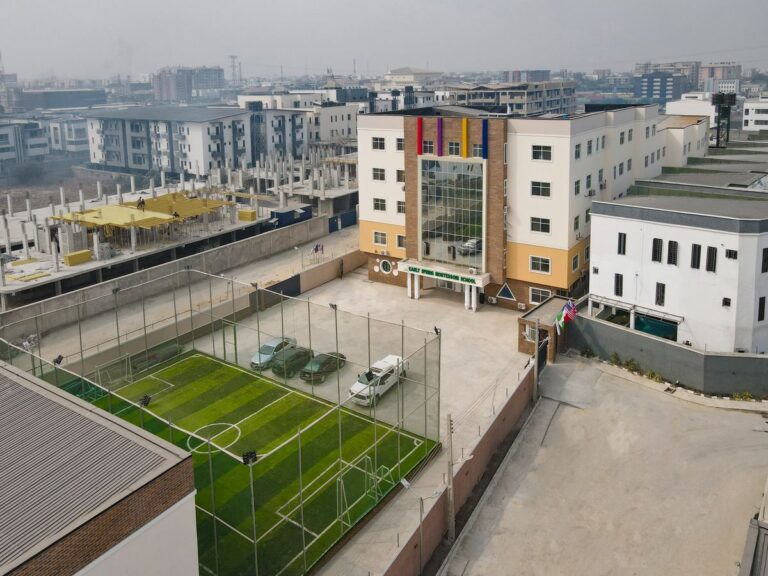 Aerial view of the school building and its fenced sports pitch